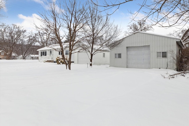 yard layered in snow featuring a garage