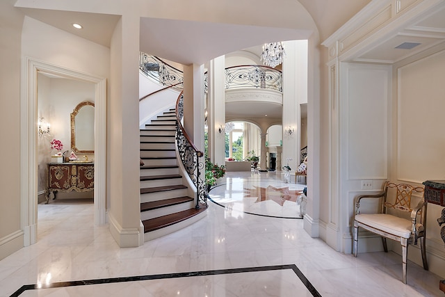 entryway with a fireplace and a chandelier