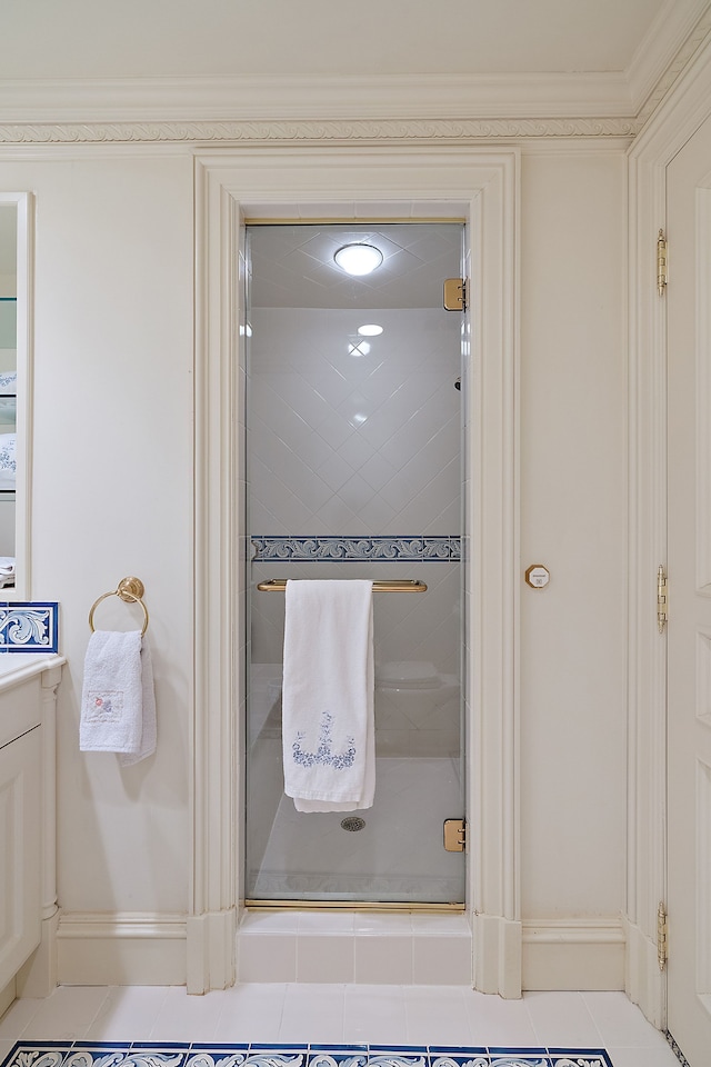 bathroom featuring vanity, tile patterned flooring, a shower with door, and ornamental molding