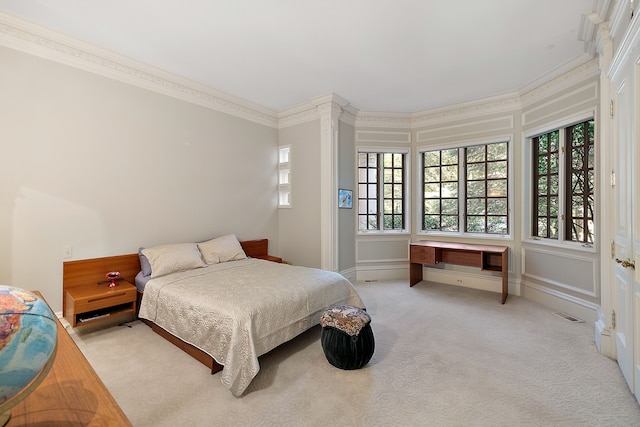 bedroom with crown molding and light colored carpet