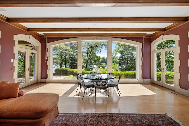 unfurnished sunroom with beam ceiling and french doors