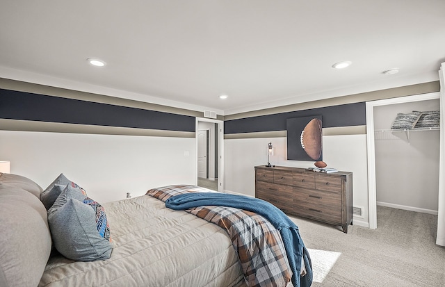 bedroom with a walk in closet, light colored carpet, and a closet