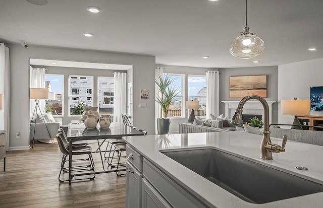 kitchen featuring sink, dark hardwood / wood-style flooring, a wealth of natural light, and pendant lighting