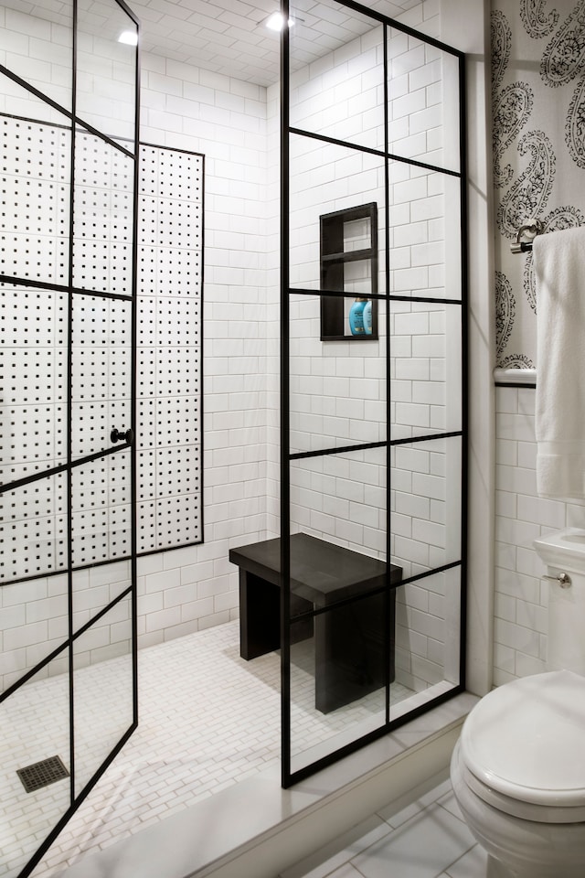 bathroom with walk in shower, tile patterned flooring, and toilet