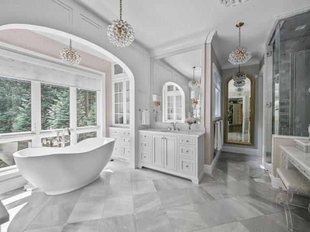 bathroom with a washtub, a chandelier, crown molding, and vanity