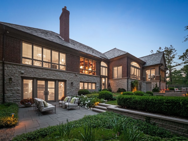 back house at dusk with a patio