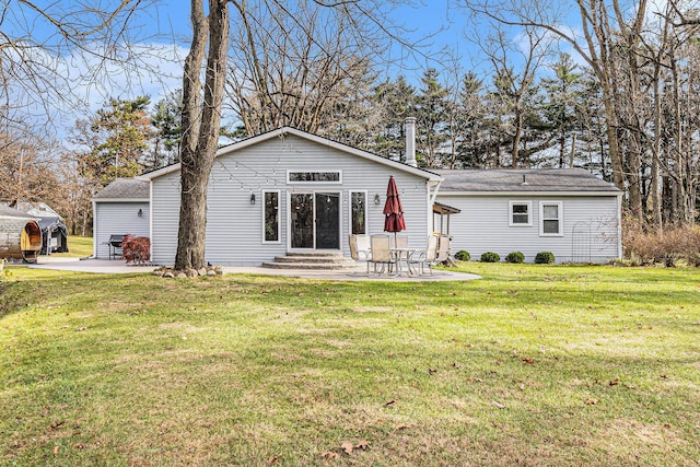 rear view of property with a yard and a patio