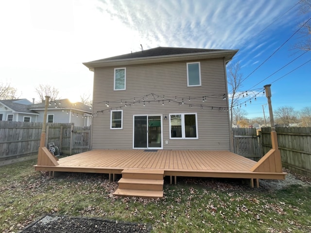 rear view of property with a lawn and a deck