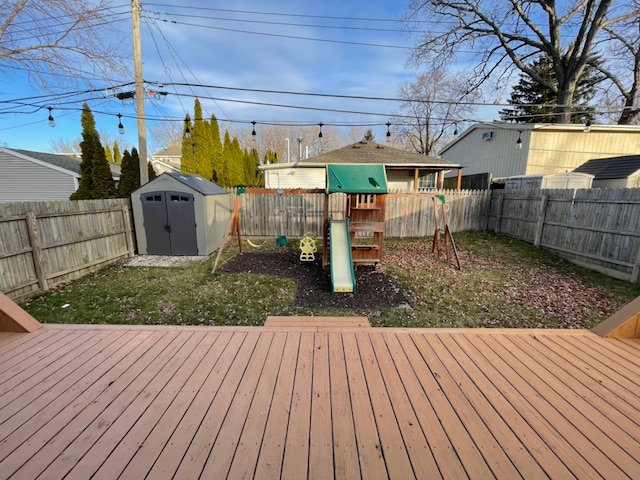 wooden deck with a playground and a shed