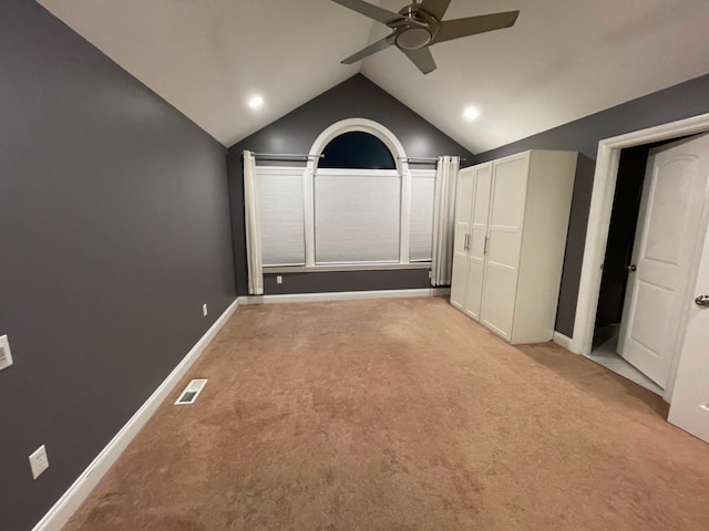 interior space featuring lofted ceiling, light colored carpet, and ceiling fan