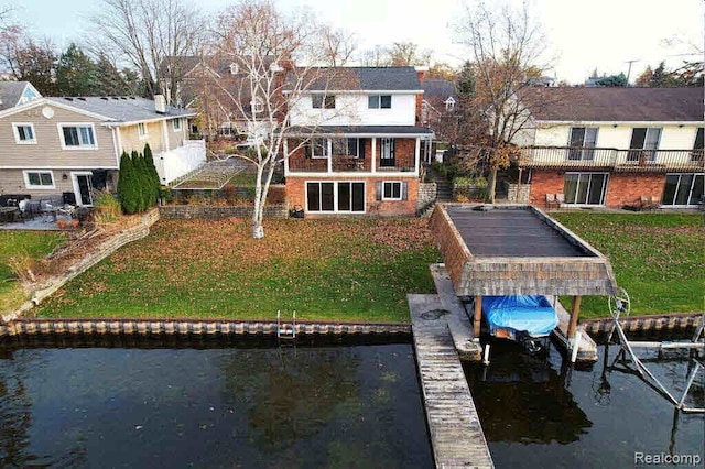 back of property featuring a water view and a lawn