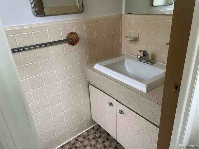 bathroom featuring tile patterned flooring, vanity, and tile walls