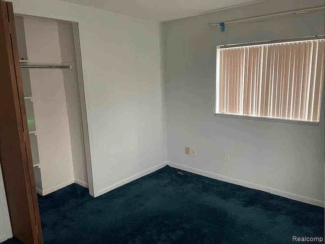 unfurnished bedroom with dark colored carpet