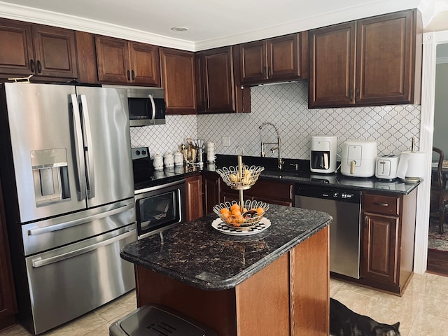 kitchen featuring stainless steel appliances, light tile patterned floors, a kitchen island, ornamental molding, and sink