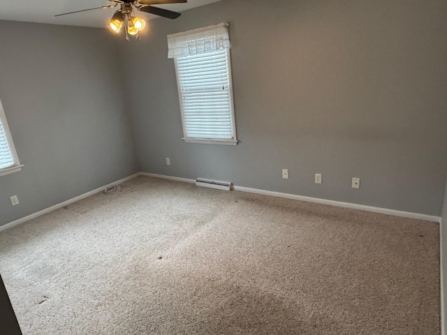 carpeted spare room with a baseboard heating unit and ceiling fan