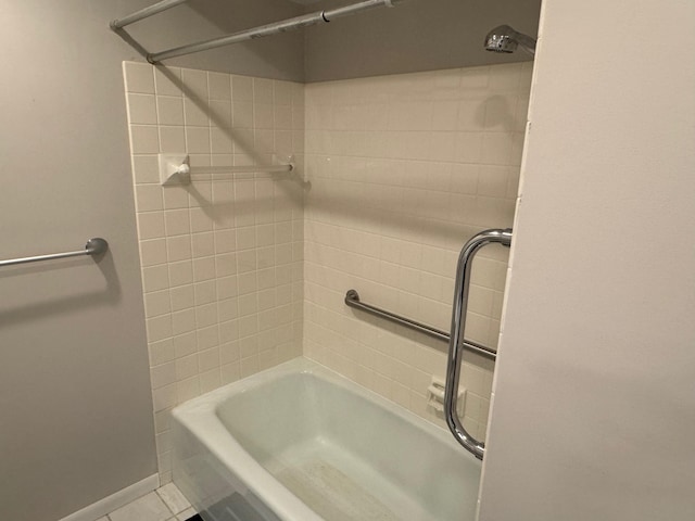 bathroom featuring tiled shower / bath combo and tile patterned flooring