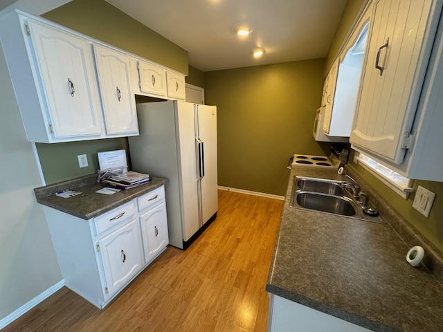 kitchen featuring sink, white cabinetry, white appliances, and light hardwood / wood-style floors