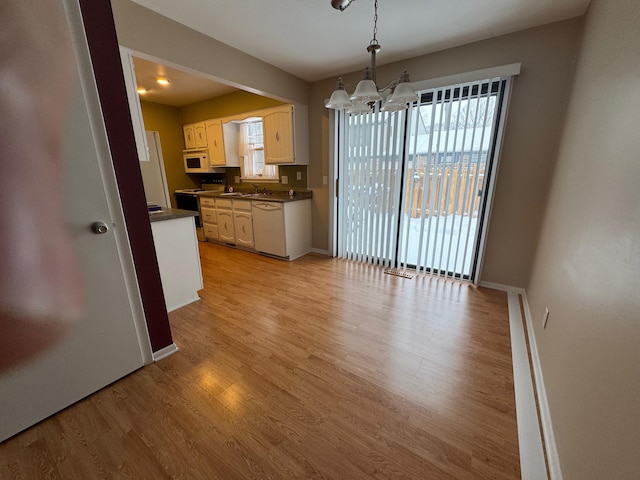 kitchen featuring decorative light fixtures, white cabinetry, white appliances, light wood-type flooring, and a notable chandelier