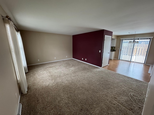 unfurnished room with carpet flooring and a notable chandelier