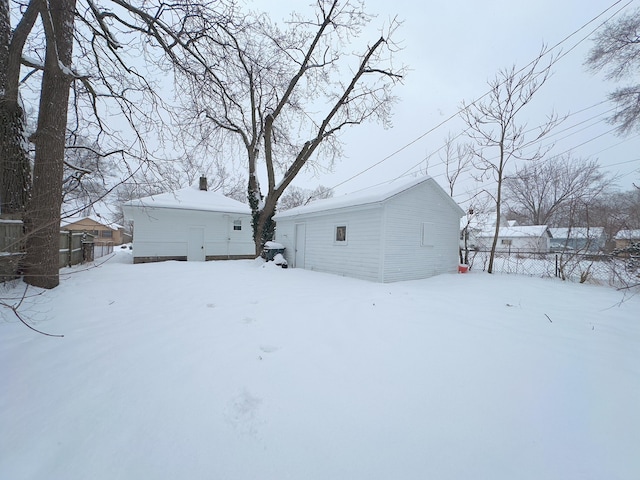 snow covered property with an outbuilding