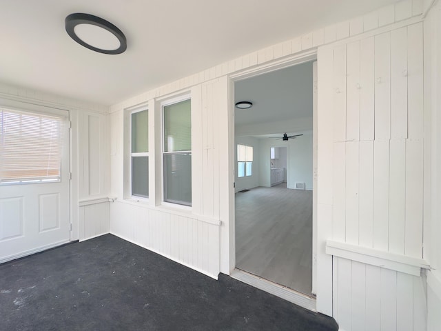 unfurnished sunroom with ceiling fan and plenty of natural light