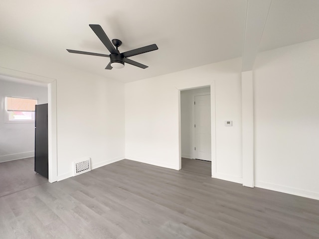 spare room with dark wood-type flooring and ceiling fan