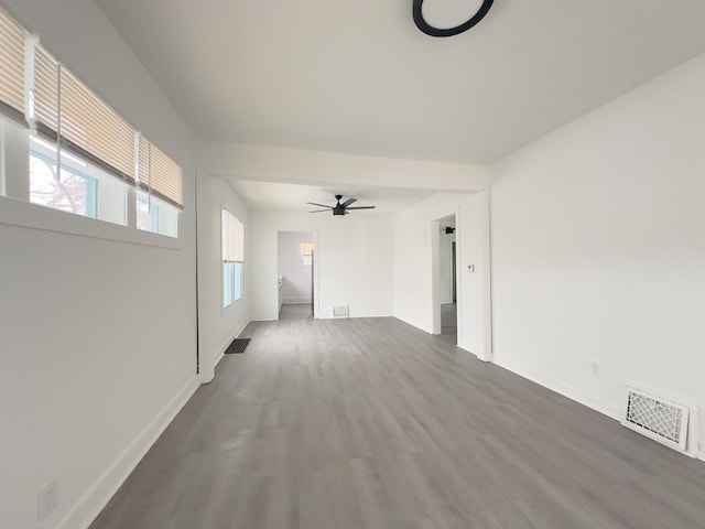 spare room with ceiling fan, a healthy amount of sunlight, and wood-type flooring