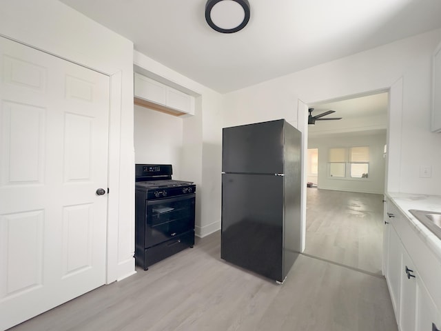 kitchen featuring black appliances, ceiling fan, white cabinetry, and light wood-type flooring