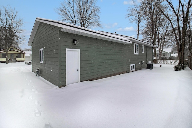 snow covered structure featuring central air condition unit