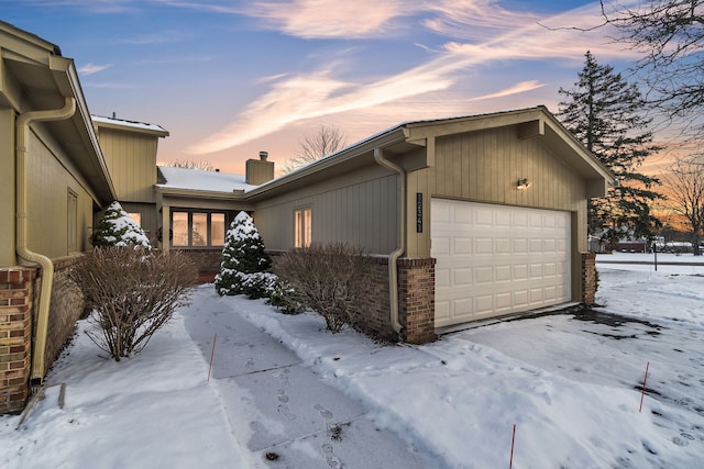 view of snowy exterior featuring a garage