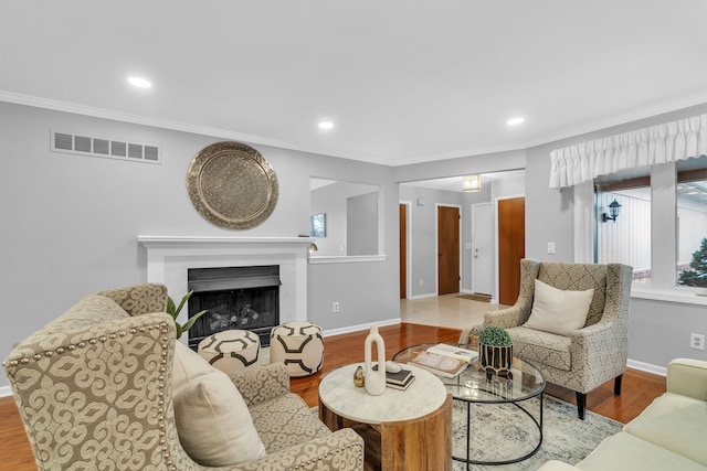 living room featuring ornamental molding and light hardwood / wood-style flooring