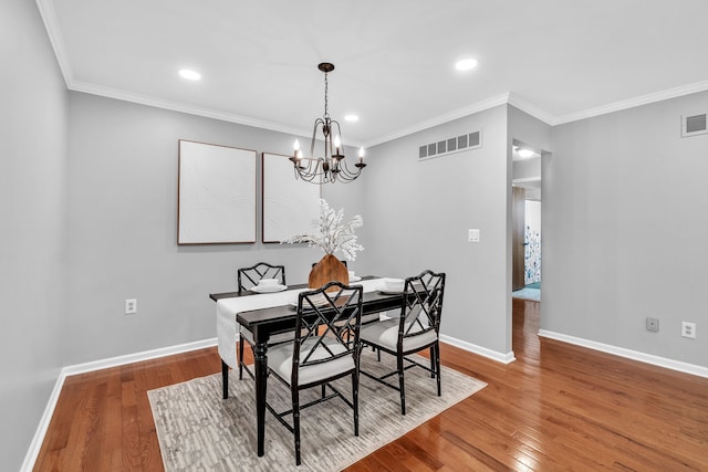 dining space with a chandelier, hardwood / wood-style flooring, and ornamental molding