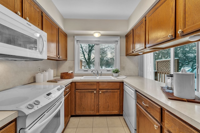 kitchen with sink, white appliances, and light tile patterned floors