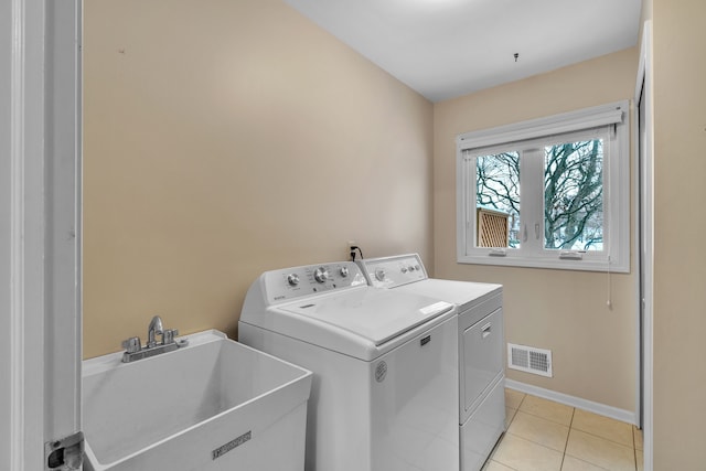 laundry area featuring sink, independent washer and dryer, and light tile patterned floors