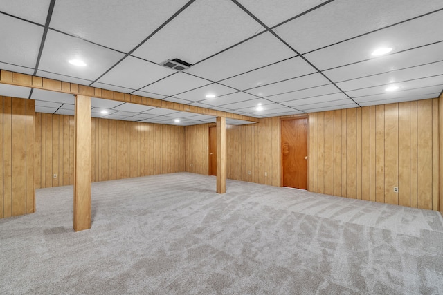 basement featuring wooden walls and carpet flooring