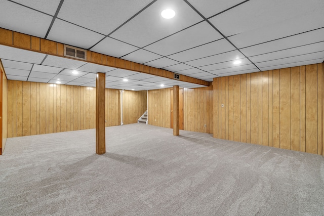 basement featuring wooden walls and carpet