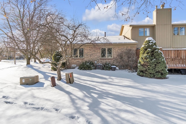 snow covered house with a wooden deck