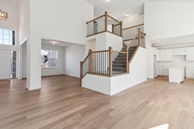 entrance foyer featuring light hardwood / wood-style floors and a towering ceiling