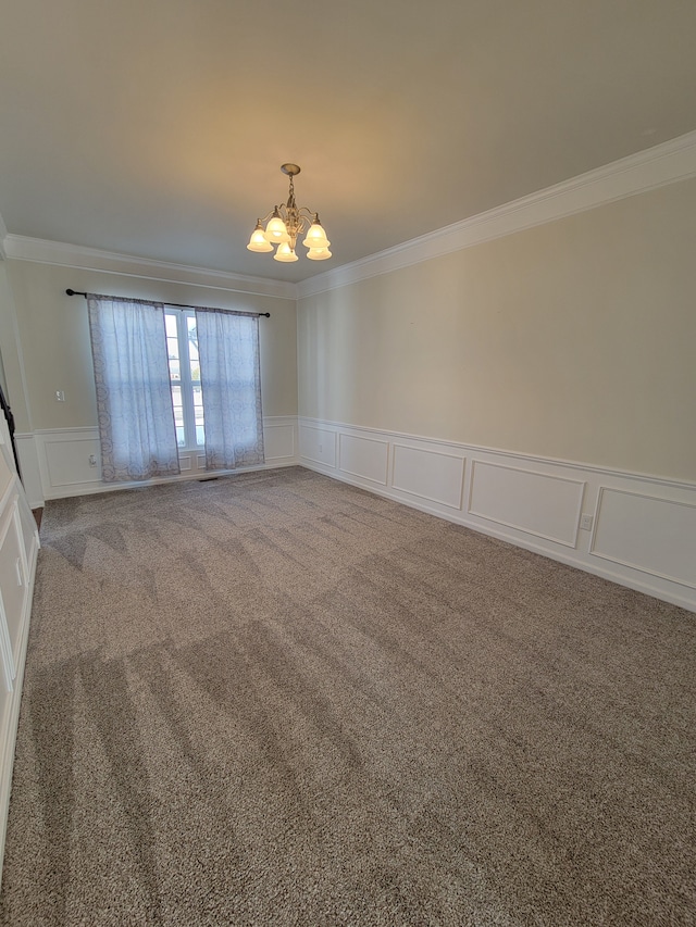 spare room with crown molding, a chandelier, and carpet