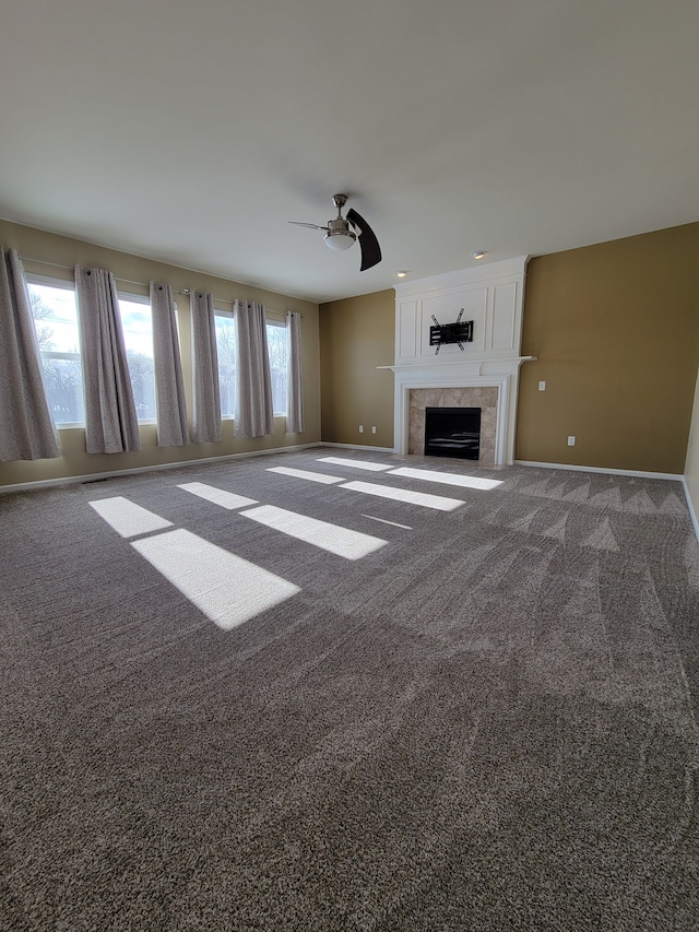 unfurnished living room featuring ceiling fan, carpet, and a fireplace