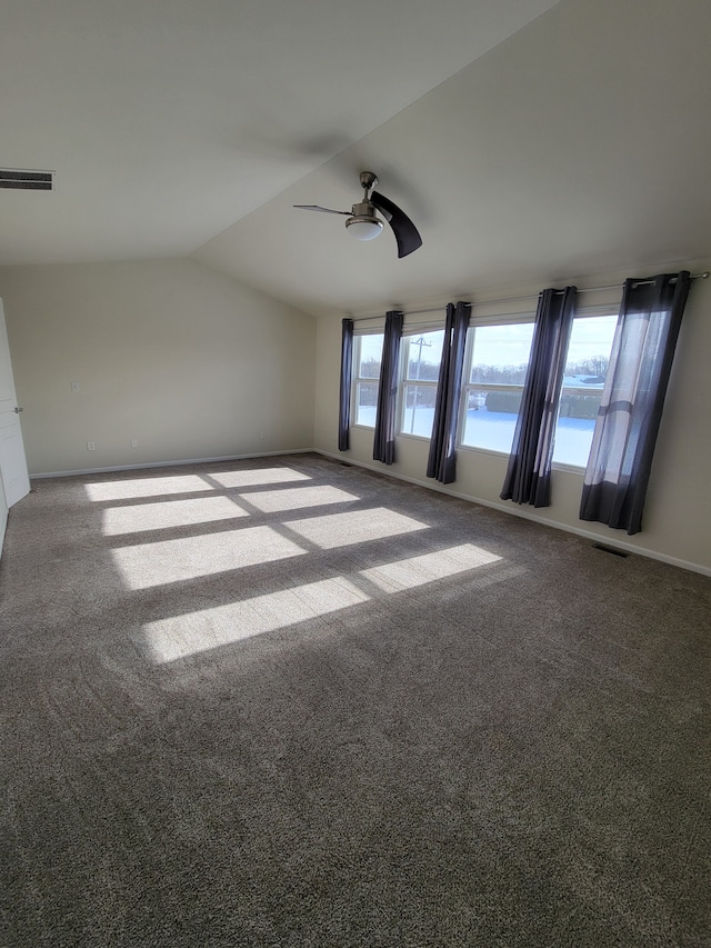 carpeted spare room featuring lofted ceiling and ceiling fan