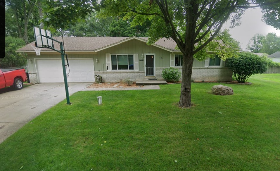 ranch-style home with a front yard and a garage