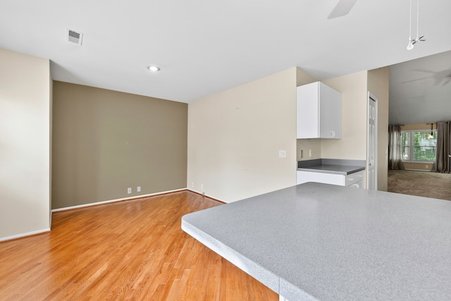 unfurnished living room featuring ceiling fan and light hardwood / wood-style flooring