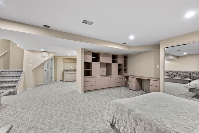 carpeted bedroom featuring sink and built in desk