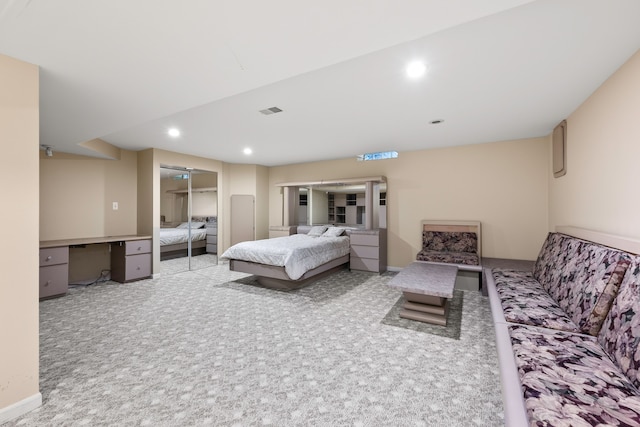 carpeted bedroom with a closet and built in desk