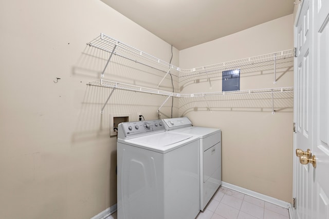 clothes washing area with washing machine and dryer and light tile patterned floors