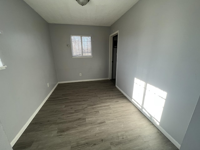 unfurnished room with wood-type flooring