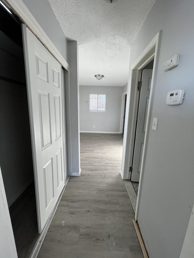 hallway featuring a textured ceiling and hardwood / wood-style flooring