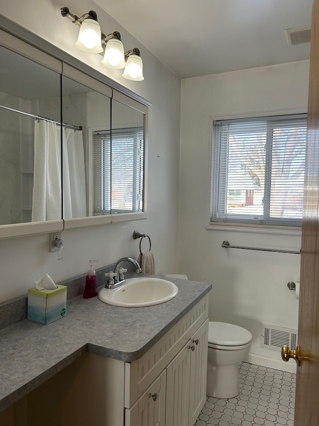 bathroom with a healthy amount of sunlight, visible vents, and vanity