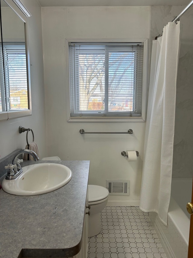 full bathroom featuring tile patterned flooring, plenty of natural light, shower / tub combo with curtain, and toilet